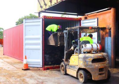 scrap items being loaded into a container to export